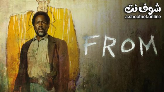 A man in a brown suit stands against a peeling yellow wall with the word 'FROM' spray-painted in white to his right.